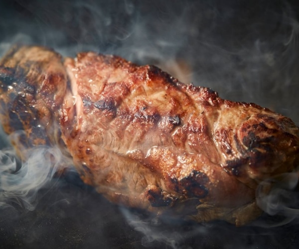 a steak cooking on grill