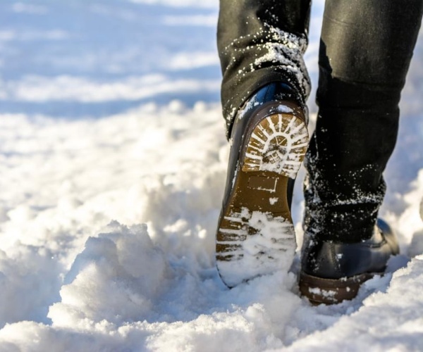 man with boots walking in snow