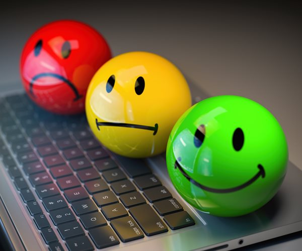 colored balls with various faces sitting on a laptop