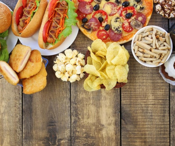 a variety of ultra-processed foods on a wood table