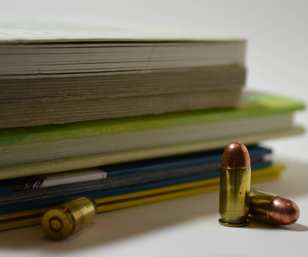 bullets in front of a stack of childrens books