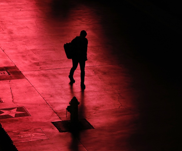 person silhouetted in black walks along the las vegas strip devoid of the usual crowds 