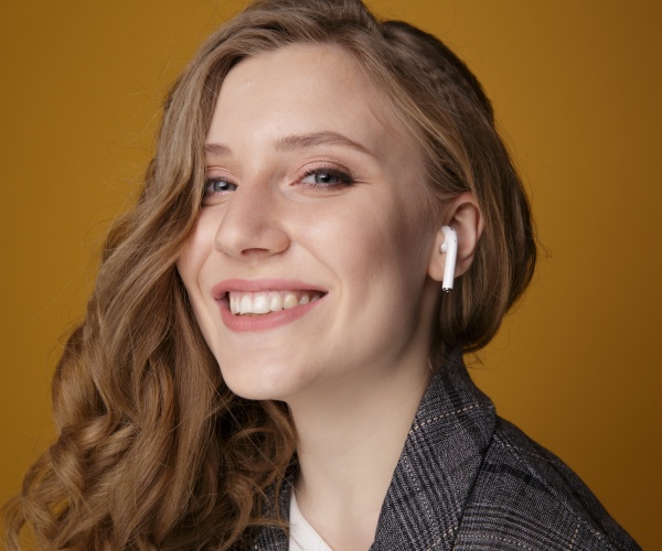 woman smiling with an AirPod in her ear