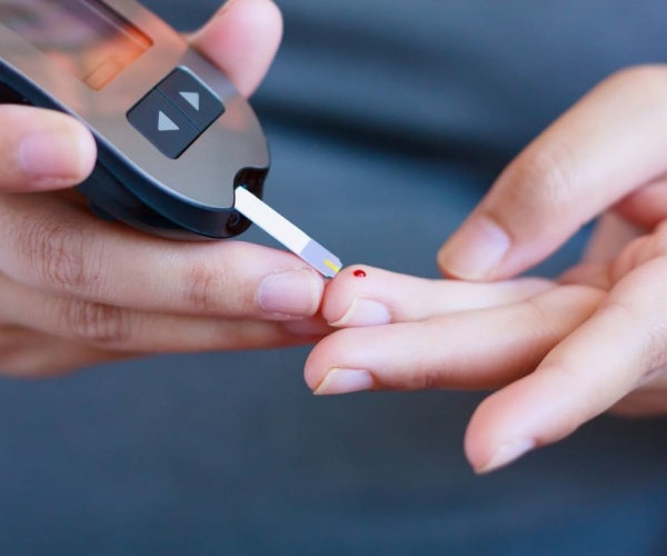 person pricking finger for blood glucose reading