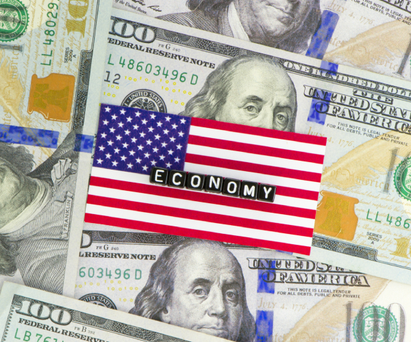 an american flag atop bills with the word "economy" on the flag