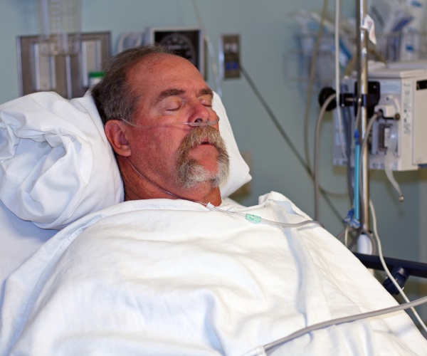 man asleep in hospital bed