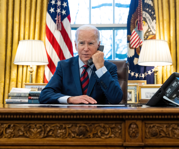 joe biden at his desk in the oval office speaking on the phone