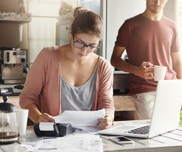 woman looking through medical bills as husband looks on