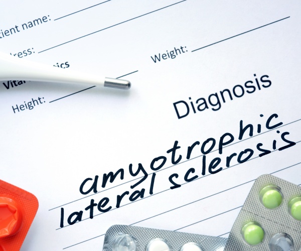 diagnosis pad with "amyotrophic lateral sclerosis" written on it, with medications and stethoscope around it