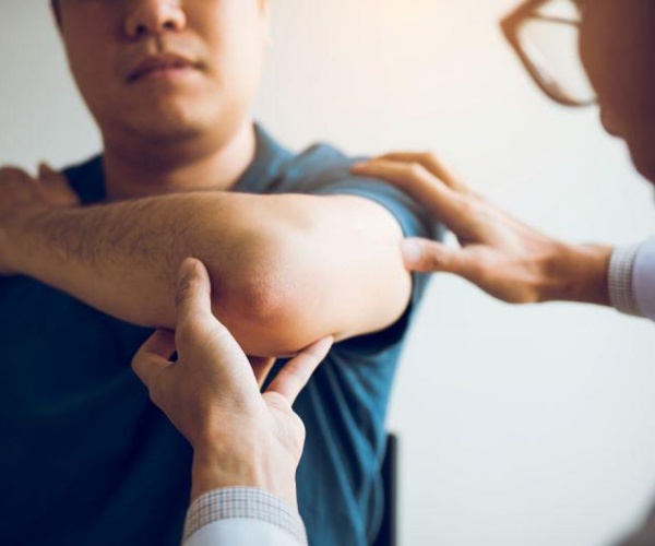 doctor examining a patient's elbow