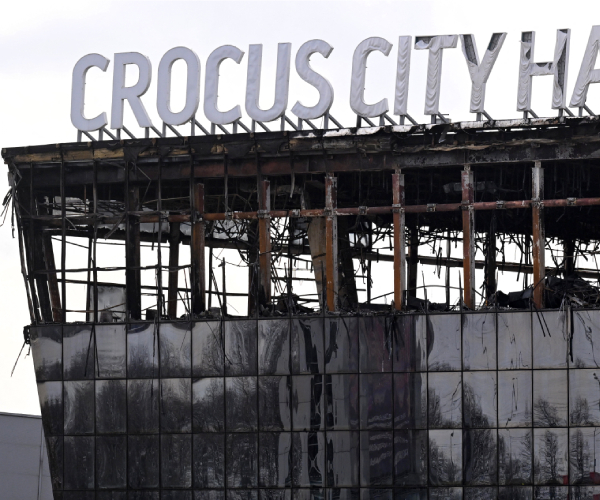 sign reading crocus city hall on top of burned building