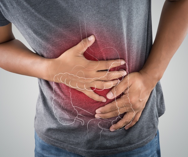 man holding stomach, with outline of colon, in pain