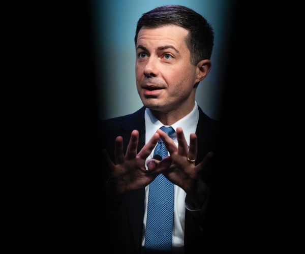 transportation secretary pete buttigieg speaks framed in black