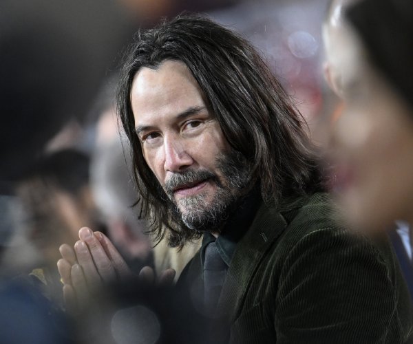 Keanu Reeves looks on