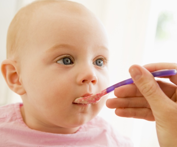 baby being fed blended food on spoon