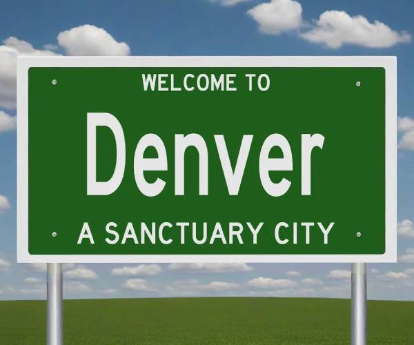 a road sign reading welcome to denver a sanctuary city