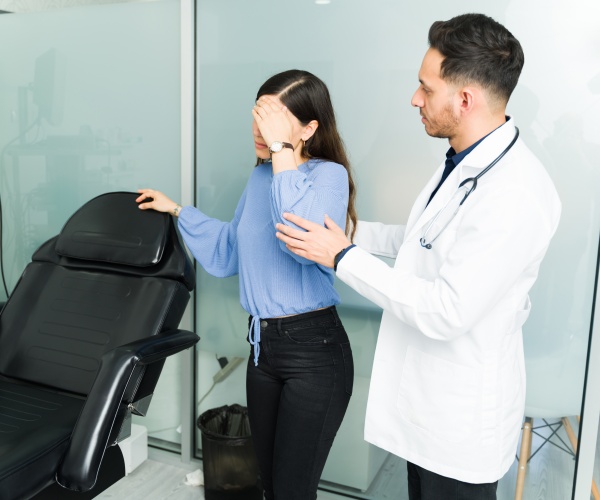 physician helping a woman in pain in office