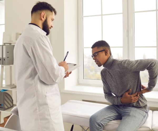 doctor talking to a patient who is explaining his back pain