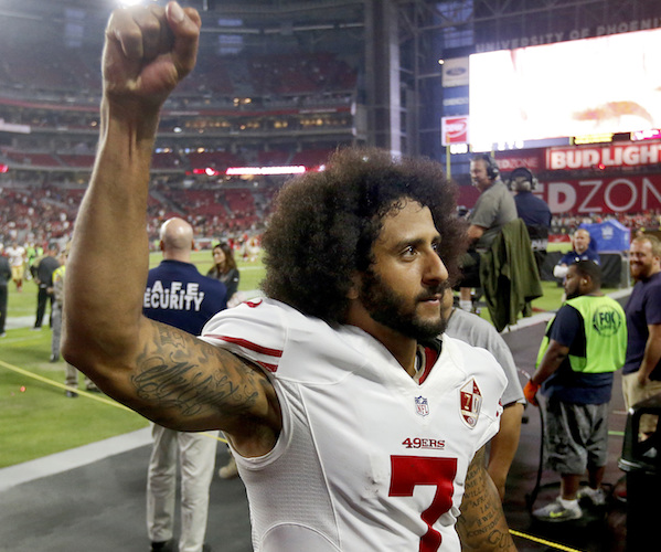 colin kaepernick holds up a black power fist as he leaves the field when he was with the san francisco 49ers