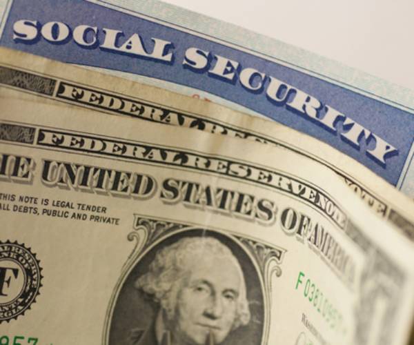 a social  security card rolled up in dollar bills