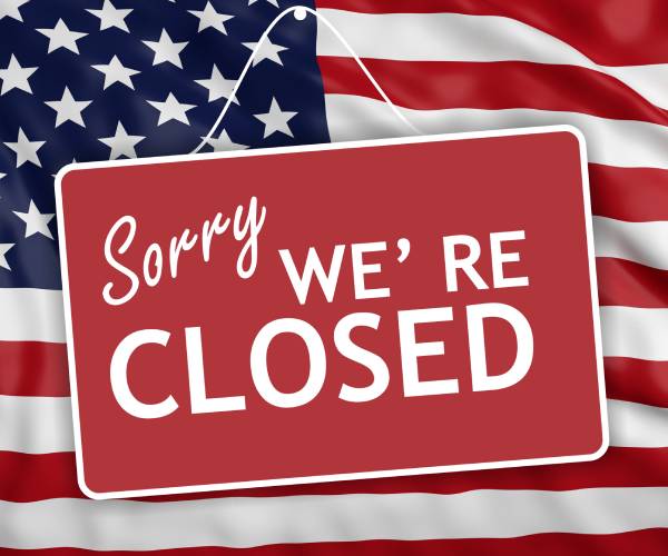 american flag with sorry we're closed sign over it