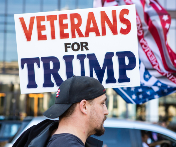 a man holds a veterans for trump sign