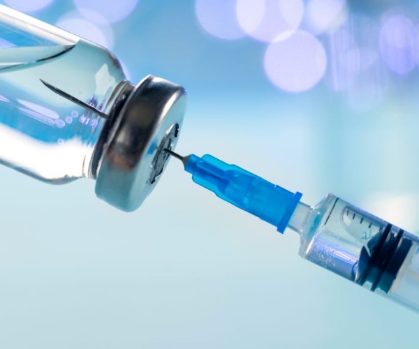 syringe in vial of COVID vaccine