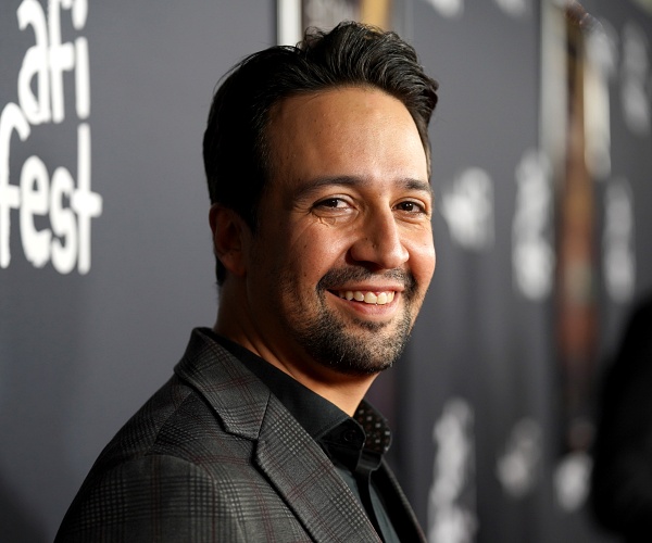 lin manuel miranda stands on red carpet