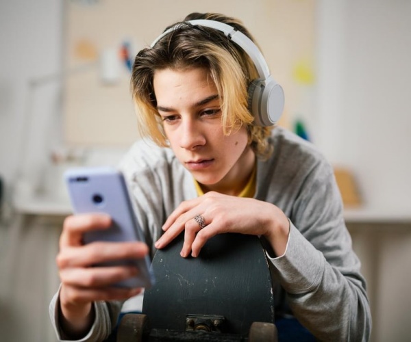 teen boy on smartphone with headphones