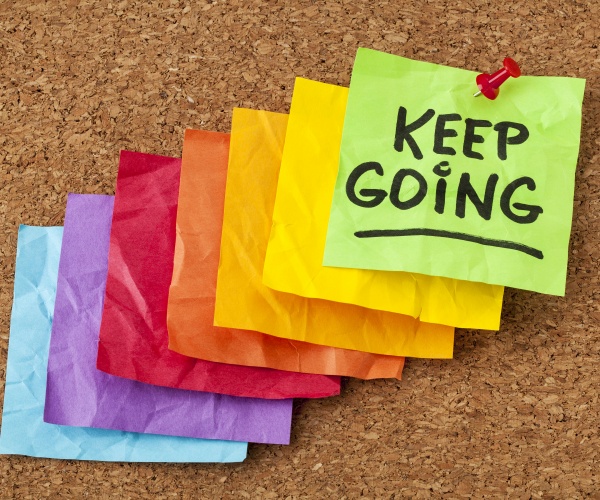 different color post-it notes making forming steps up to the last note that says 'Keep Going'