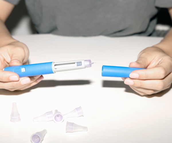 woman holding an Ozempic pen cartridge