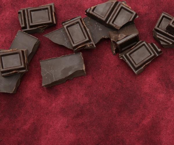 dark chocolate pieces on red background