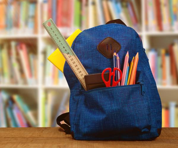 a school backpack in front of bookshelves