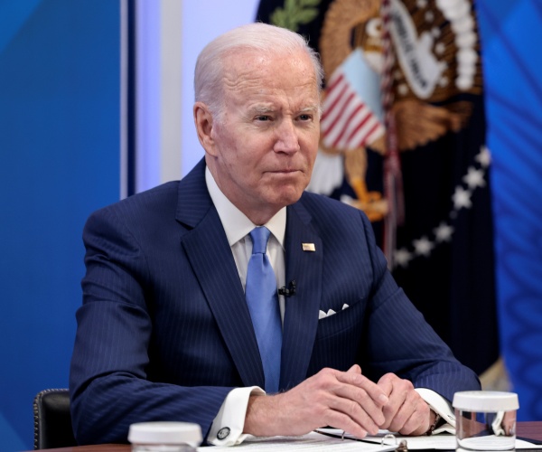 joe biden sits at a desk