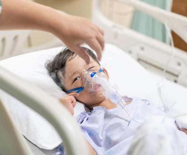 young boy in hospital with oxygen mask