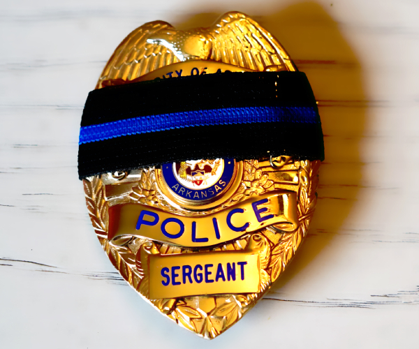 a police badge with a black band indicating mourning