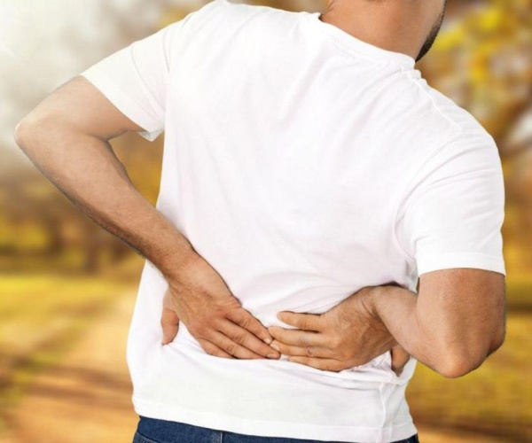 man holding lower back in pain