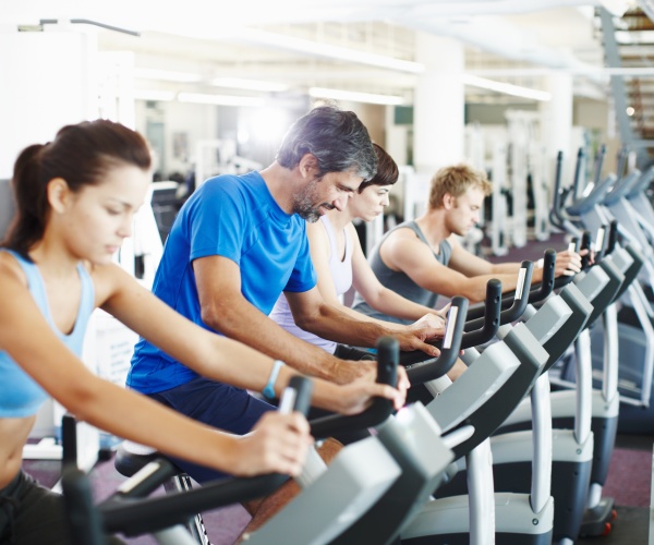 men and women in gym on cardiovascular machines