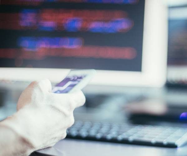 a computer hackers hand and a computer screen