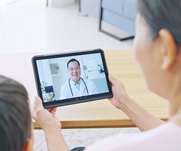 mother and son on tablet for telehealth with doctor