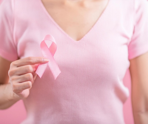 young woman in pink t-shirt, holding pink ribbon