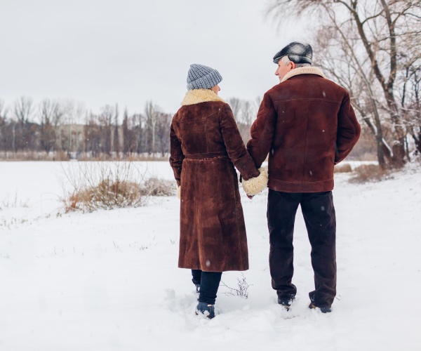 older couple out walking in winter snow