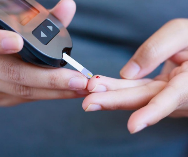 person performing blood glucose test