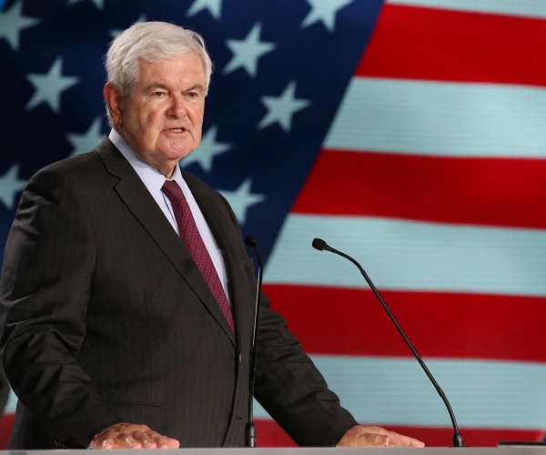 newt gingrich stands behind podium