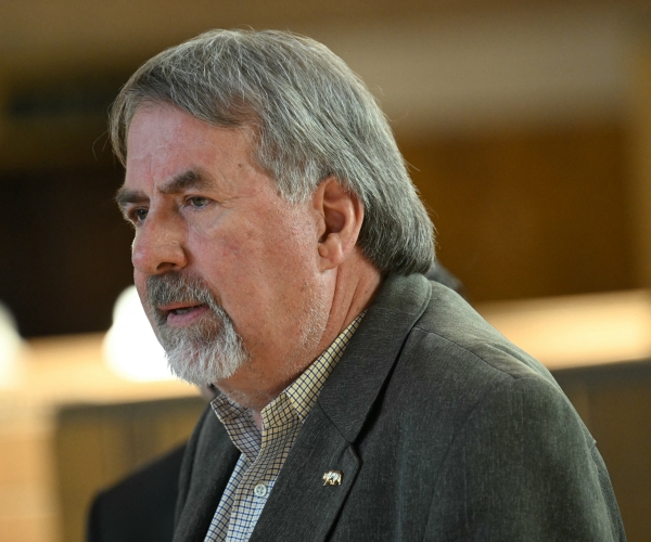 a bearded man looks on