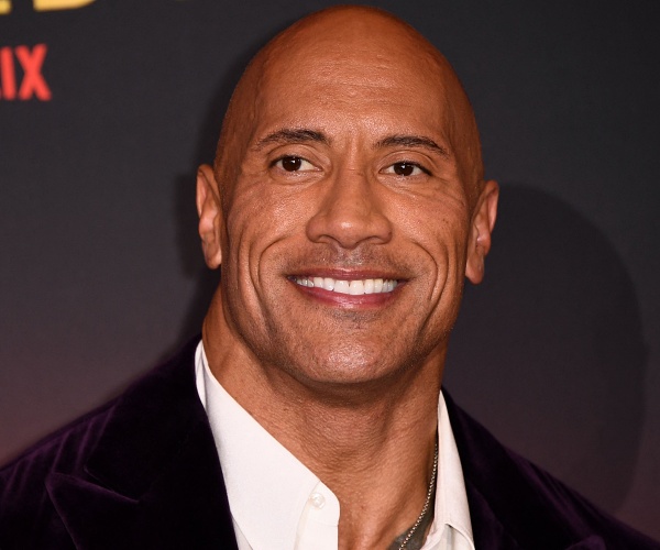 dwayne johnson stands on red carpet