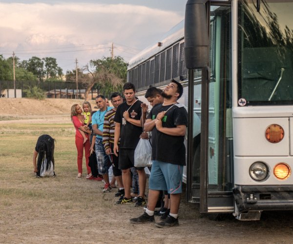 migrants prepare to board a border patrol bus in texas 