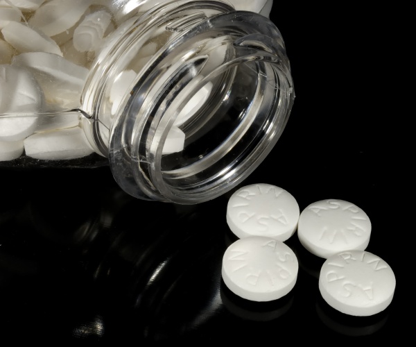 aspirin spilling out on table from container